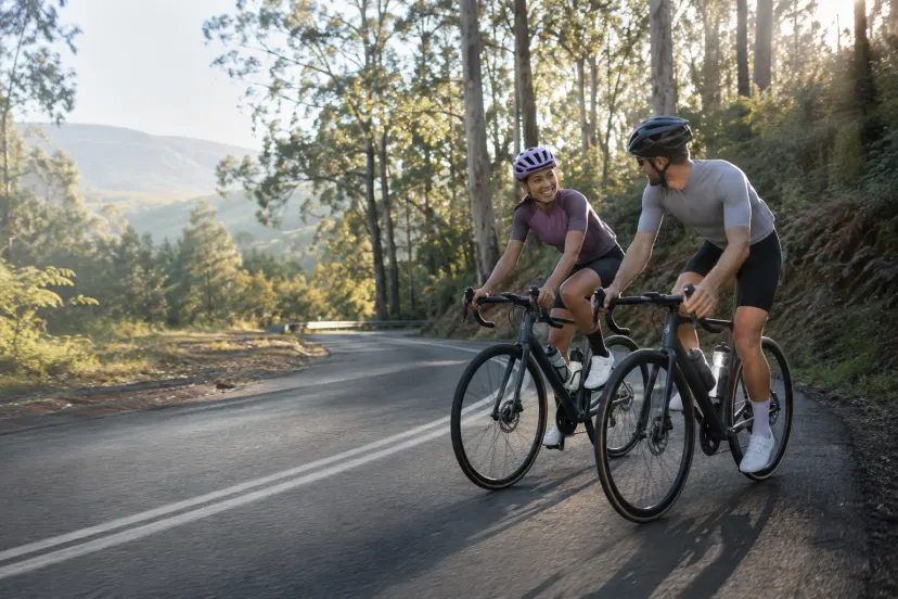 Two adult road cyclists riding together on a scenic sealed road near Melbourne
